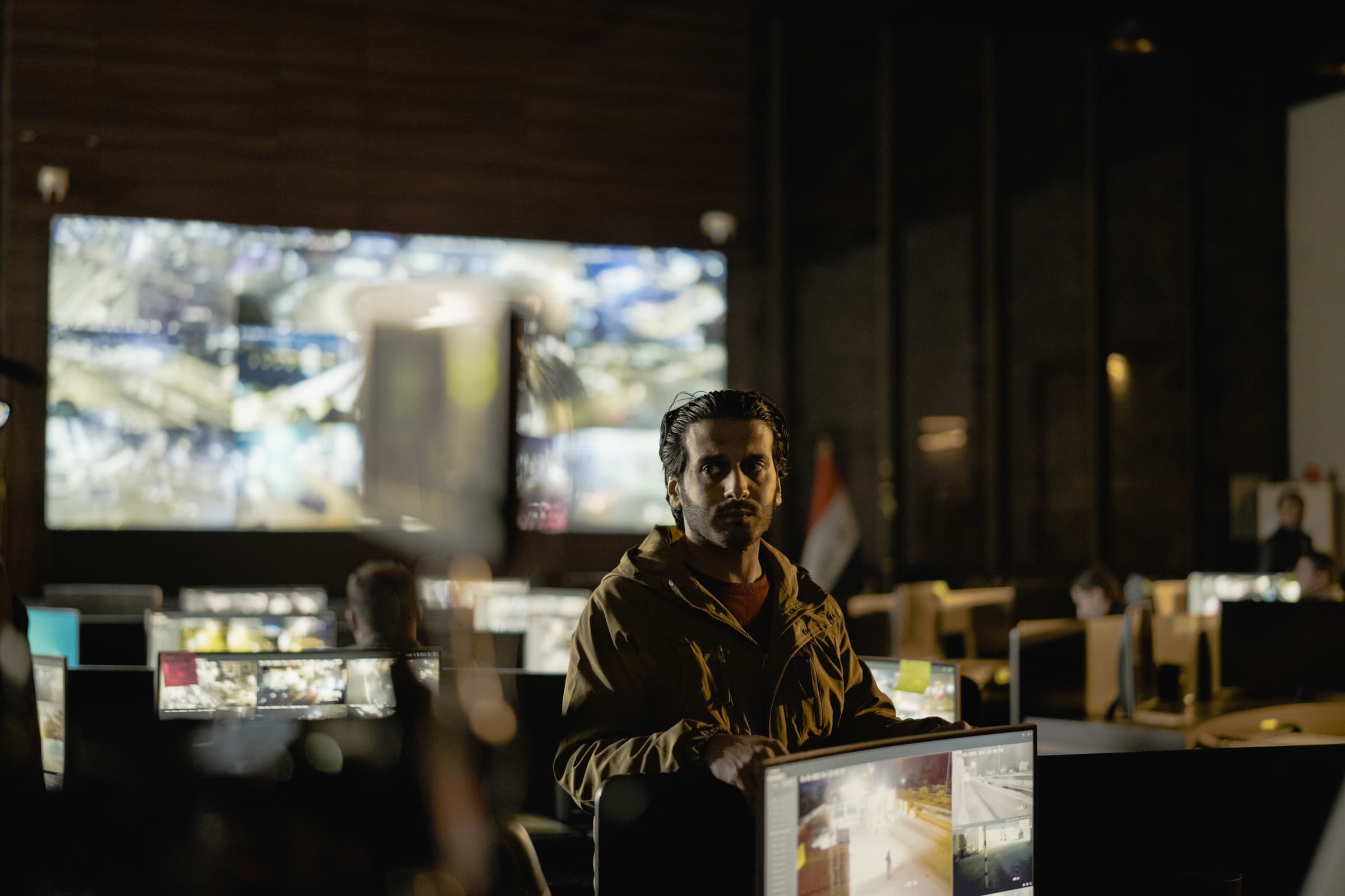 Security operations center analysts monitoring threat dashboards in a dim control room